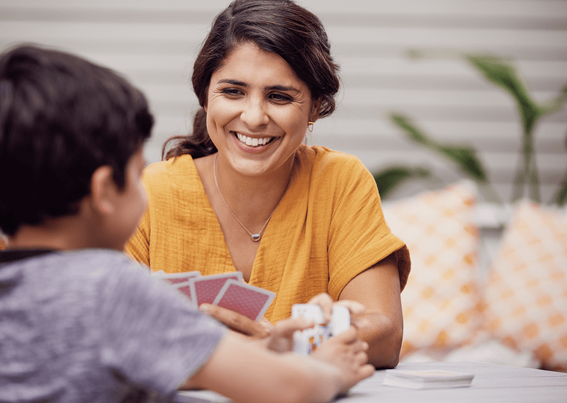 Lady playing cards with young boy